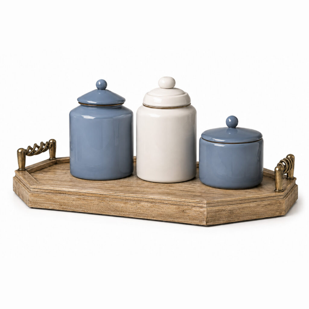 Vintage mango wood tray with antique brass handles and three glossy porcelain canisters in dusty blue and warm ivory on a white background.