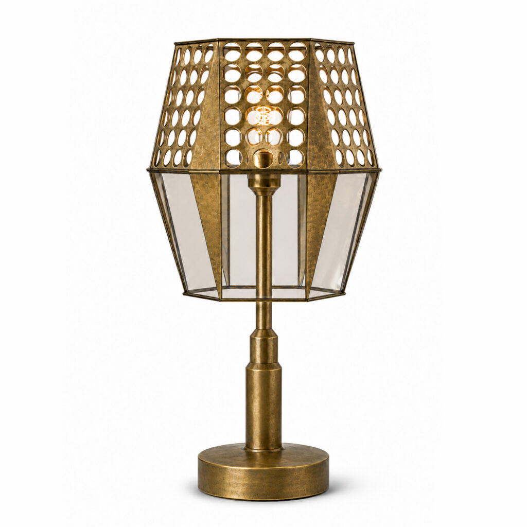 Antique brass table lamp with a perforated metal shade, tinted glass panels and a round base on a white background.